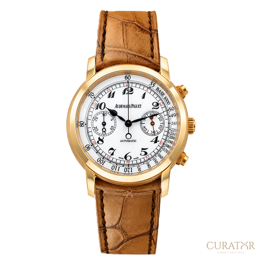 A luxury wristwatch by Audemars Piguet, featuring a gold-tone case, a white dial with black Arabic numerals and sub-dials, and a brown alligator-textured leather strap, shown against a plain white background.