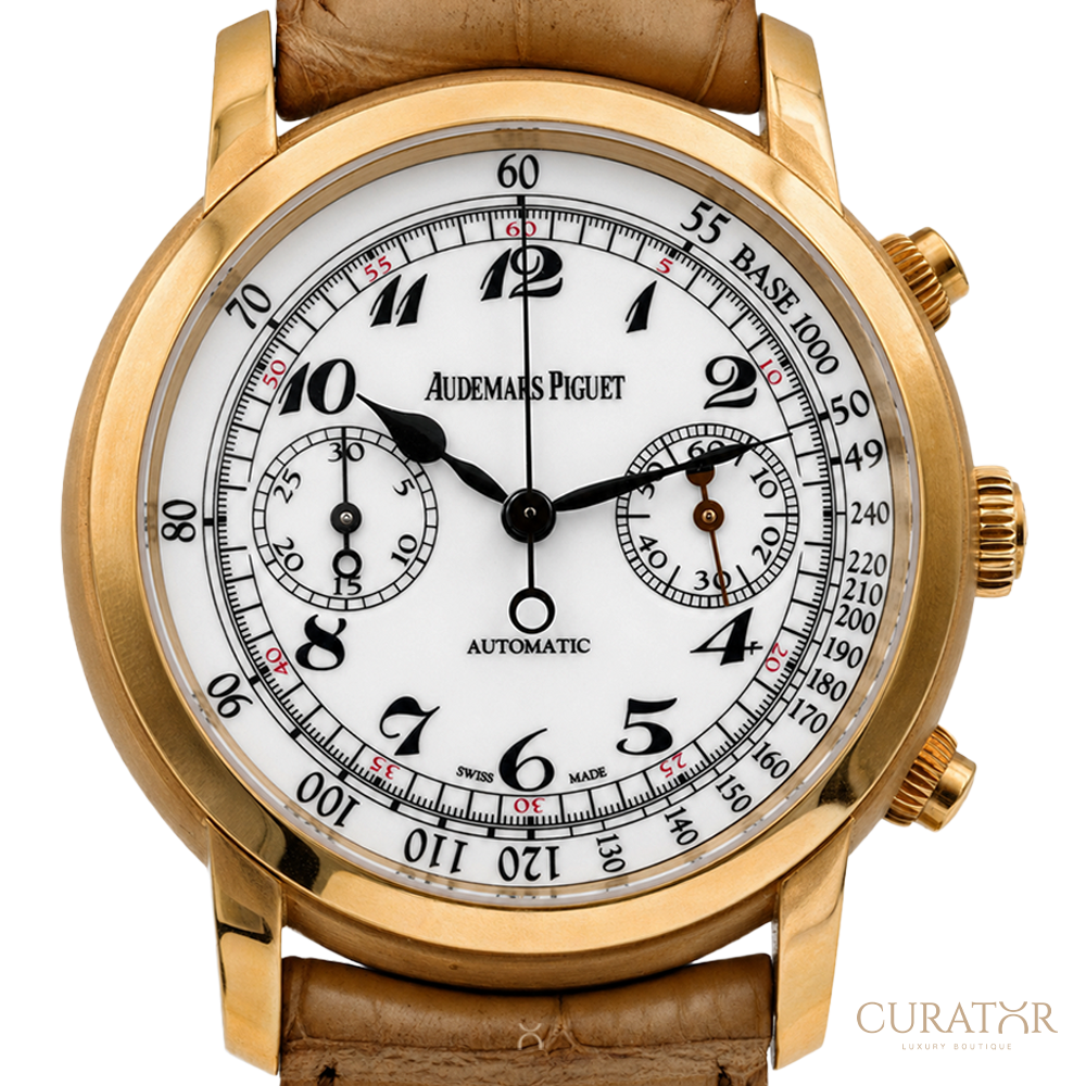A close-up studio shot of an Audemars Piguet Automatic watch with a gold-tone case, white dial, black and red markings, and a brown leather strap on a white background.